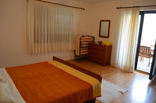 a bedroom with a bed and a dresser and a window at Apartments Ana in Baška