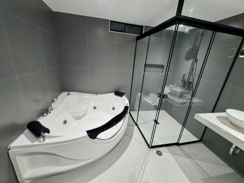 a bathroom with a tub and a glass shower at Apartamento Paramount in Huaraz