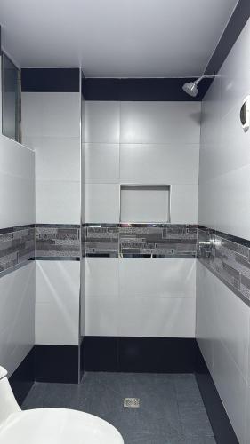 a bathroom with white walls and a toilet at Apartamento Paramount in Huaraz