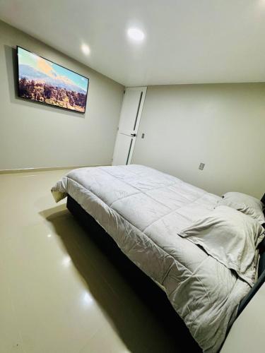 a bedroom with a bed and a tv on the wall at Apartamento Paramount in Huaraz