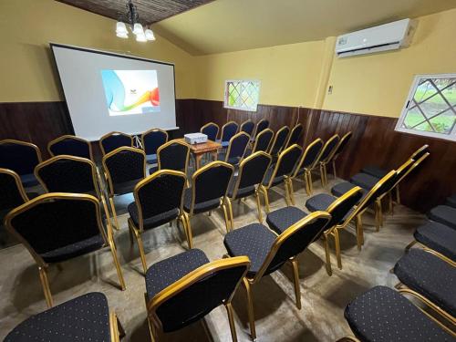 a conference room with chairs and a projection screen at Lamanai Hotel & Marina in Orange Walk