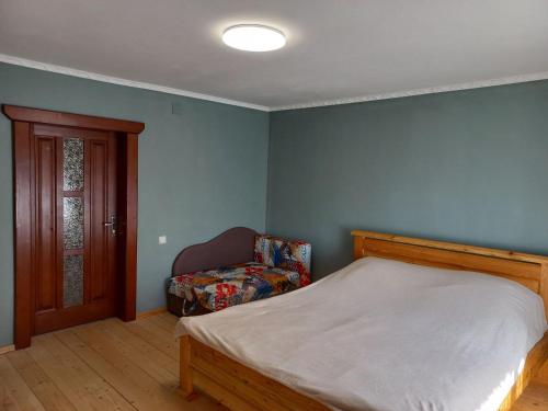 a bedroom with a bed and a chair at Садиба Стожари in Vorokhta