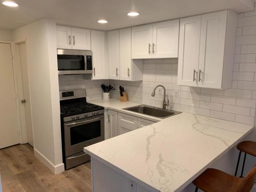 a kitchen with white cabinets and a counter top at Beautifully Remodeled 2BR Prime Irvine Location in Irvine