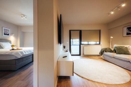 a living room with a bed and a couch at Apartament Plaza - Self Check-in in Gura Humorului