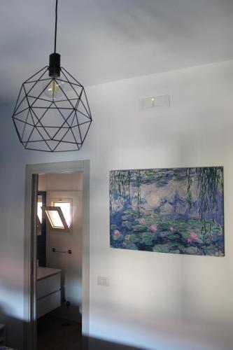 a painting and a pendant light hanging from a wall at Mar Art Sapri in Sapri