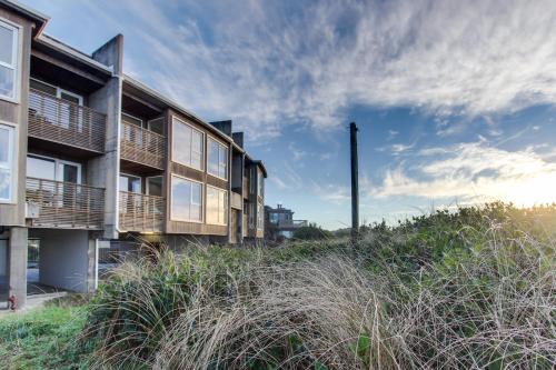an apartment building on the beach with tall grass at Romantic Manhattan Beach Sunset #202 in Rockaway Beach