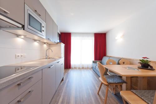 a kitchen with a table and a dining room at Mountain Residence Montana in Santa Maddalena in Casies