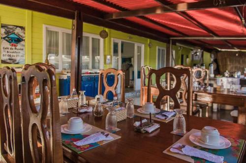 een eetkamer met een houten tafel en stoelen bij Pousada da Carmô in Fernando de Noronha