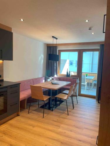 a kitchen and dining room with a table and chairs at Apart Oberau - new from 2025 in Hippach