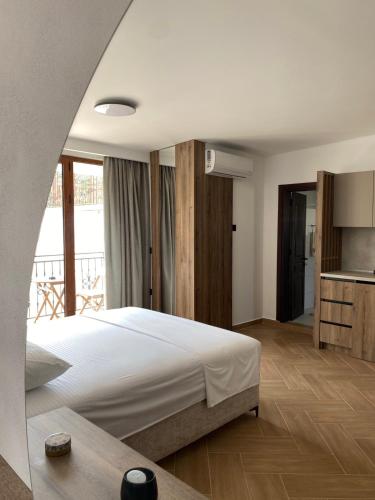 a bedroom with a large bed and a kitchen at Guesthouse Nesa in Ulcinj