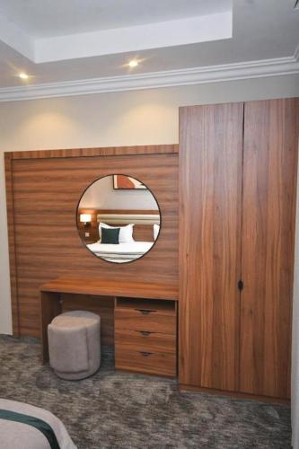 a bedroom with a circular mirror and a bed at شقق برج الفخامة in Quai