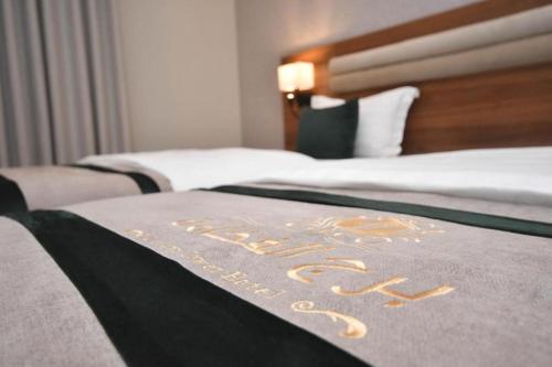 a hotel sign on a bed in a hotel room at شقق برج الفخامة in Quai