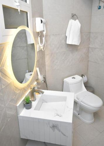a bathroom with a sink and a toilet and a mirror at شقق برج الفخامة in Quai