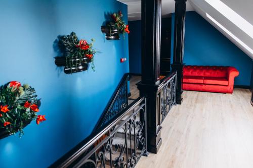 a staircase with a red bench and blue walls at Strindberg Boutique Hotel in Topliţa