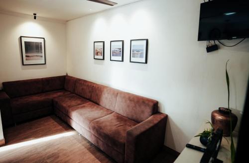a brown couch in a room with pictures on the wall at The French Square in Alleppey