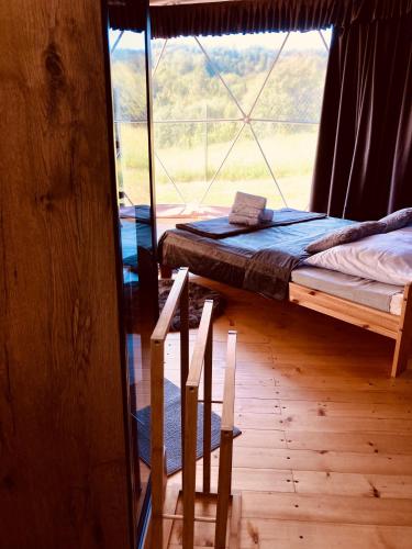 a bedroom with a bed and a large window at Poziom 713 in Trzebunia