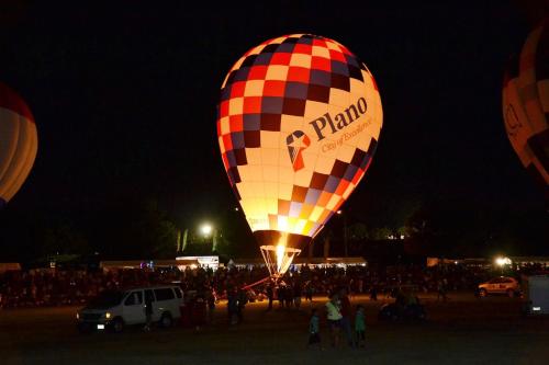 a group of hot air balloons in a field at night at Staybridge Suites Plano - Legacy West Area by IHG in Frisco