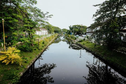 a view of a river with houses and trees at The French Square in Alleppey