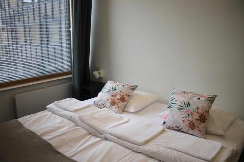 a bed with two pillows on it in a room at Aikatalo Hostel Helsinki in Helsinki