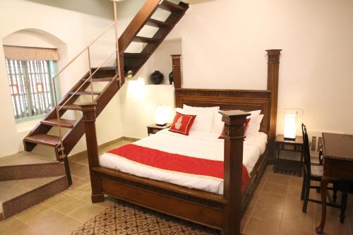 a bedroom with a bed with a staircase in it at Lar Amorosa Boutique Hotel - Goa in Calangute