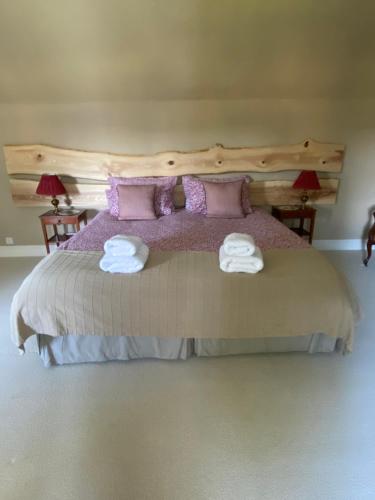 a bedroom with a large bed with towels on it at Fordie Lodge in Comrie