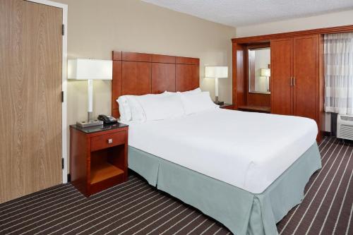 a bedroom with a large white bed and a telephone at Holiday Inn Express Hotels- Hampton by IHG in Hampton