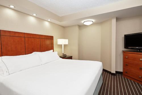 a hotel room with a bed and a flat screen tv at Holiday Inn Express Hotels- Hampton by IHG in Hampton