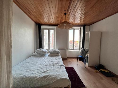 a bedroom with a large bed with a wooden ceiling at Agréable appartement neuf et lumineux in Saint-Ouen-lʼAumône