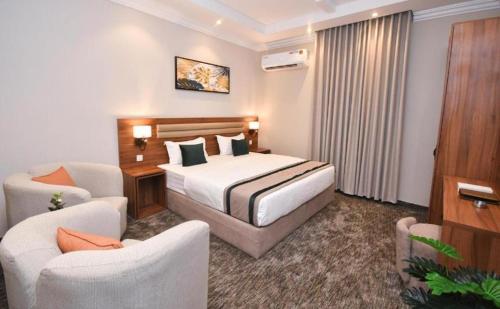 a hotel room with a bed and two chairs at شقق برج الفخامة in Quai