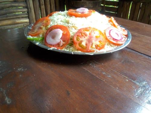 a plate of food on a wooden table at Kibale Cultural Homestay in Fort Portal