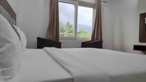 a bedroom with two beds and a window at Dreamland Resort in Nainital