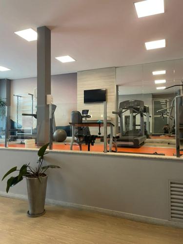 an empty gym with a desk and a treadmill at Flat Premium Vila da Serra in Nova Lima