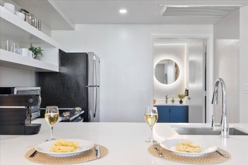 a kitchen with two plates of food and two glasses of wine at Private Oasis at Arya in Miami