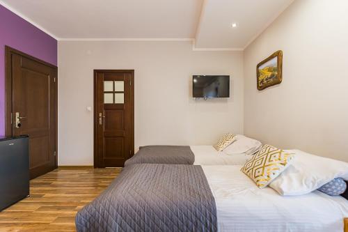 a bedroom with two beds and a tv on the wall at Noclegi Biały Bór Widok na góry i Zalew Soliński 530-487-636 in Polańczyk