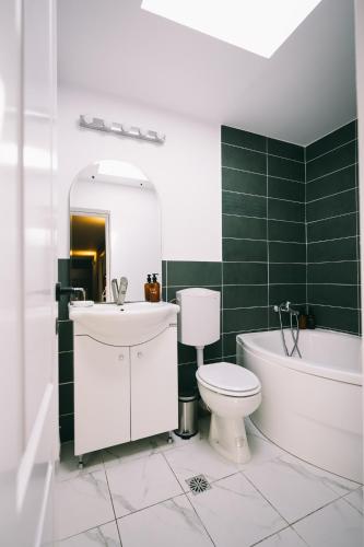 a bathroom with a toilet and a tub and a sink at Cotroceni Accommodations House in Bucharest