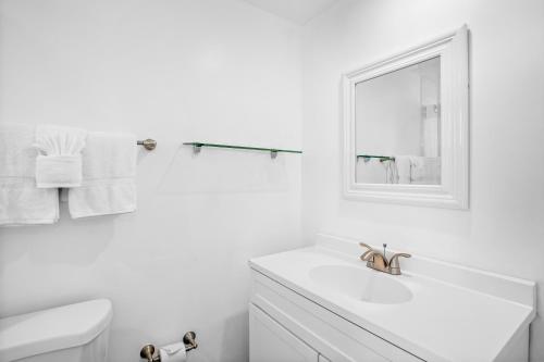 a white bathroom with a sink and a mirror at Coconut Cay Resort in Marathon