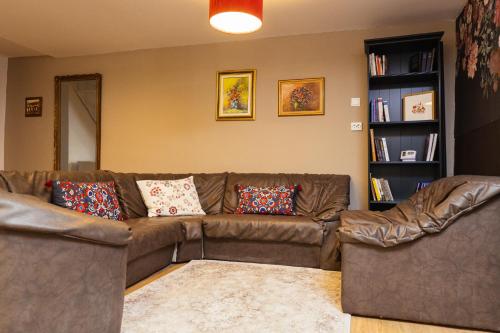 a living room with a brown couch and a book shelf at Cotroceni Accommodations House in Bucharest