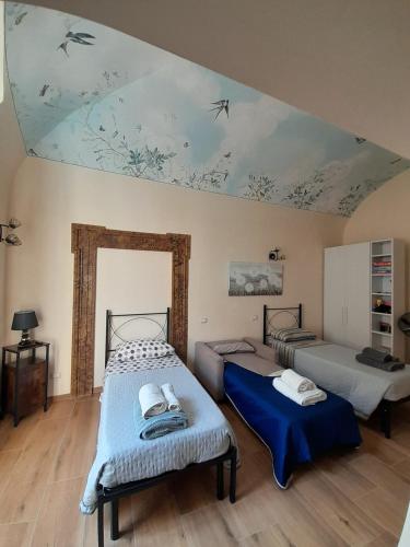 una camera da letto con due letti e un soffitto con degli uccelli sopra di Apartment Centro Storico Il cielo in una stanza a Gubbio