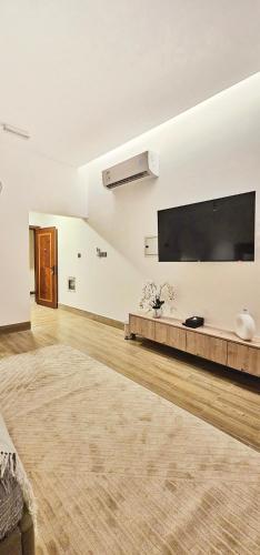 a living room with a large flat screen tv on the wall at Modern & Comfy Studio-AlGhub 13 in Ras al Khaimah