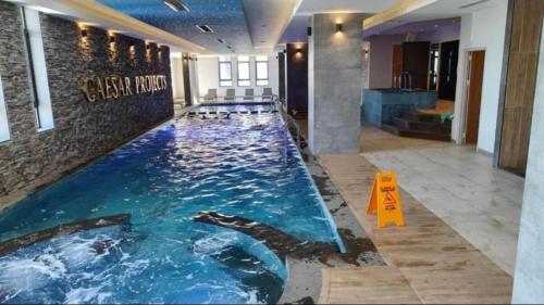 a large swimming pool in a hotel room at Апартаменты в комплексах Цезарь Бич и Цезарь Блю in Boğaz