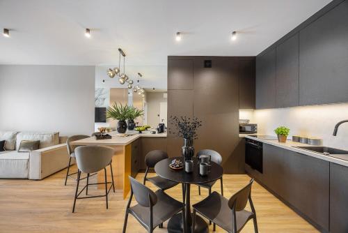a kitchen and living room with a table and chairs at Emihouse Riverside Premium Apartments & Free Parking in Rzeszów