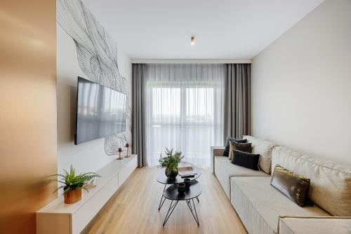 a living room with a couch and a table at Emihouse Riverside Premium Apartments & Free Parking in Rzeszów