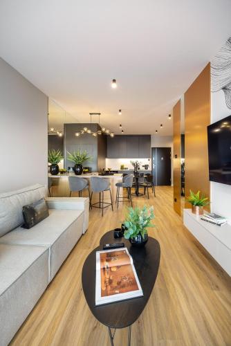 a living room with a couch and a table at Emihouse Riverside Premium Apartments & Free Parking in Rzeszów