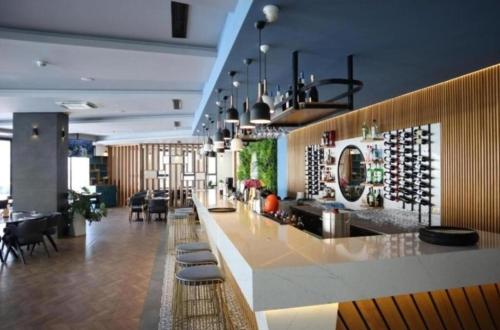 a large room with a bar with wine bottles at Апартаменты в комплексах Цезарь Бич и Цезарь Блю in Boğaz