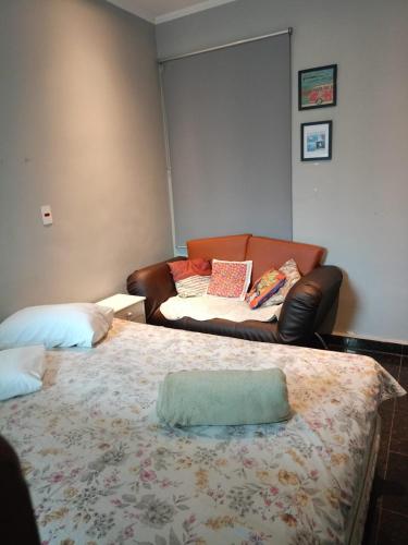 a living room with a couch and a bed at Hospedaria Casa373 valores acessíveis Vila Mariana e Vila Clementino in Sao Paulo