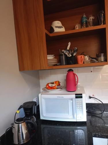 a microwave oven with a tea kettle on top of it at Hospedaria Casa373 valores acessíveis Vila Mariana e Vila Clementino in Sao Paulo