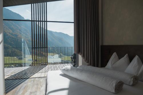 a hotel room with a bed and a balcony at Mountain Residence Montana in Santa Maddalena in Casies