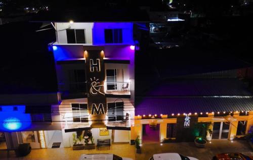 a building with purple and blue lights on it at Hotel H Y M in Palmira