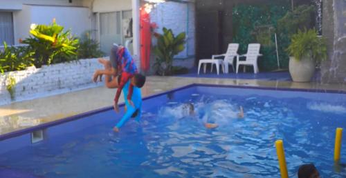two children are playing in a swimming pool at Hotel H Y M in Palmira