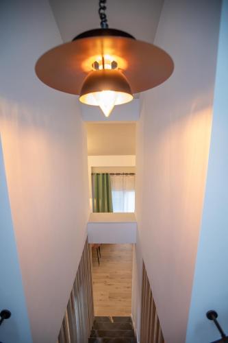 a hallway with a ceiling light and a hallway with a table at Serenity Karditsa Lofts in Kardítsa